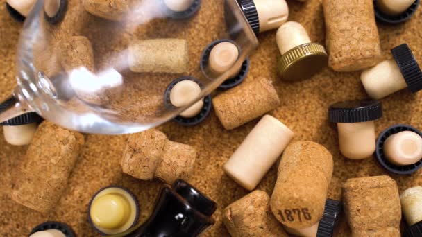 Corks from bottles of red wine. Top View Crane wine glasses, corks, bottle on a brown background. Smooth camera movement. Closeup of wine corks. Many different wine corks — Stock Video