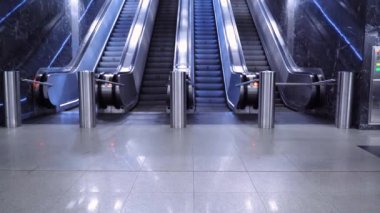 Metrodaki büyük modern yürüyen merdiven. Dört şeritte yukarı aşağı hareket eden insanlar olmadan terk edilmiş yürüyen merdiven. Çizgiler, ışık. Boş metro, insan yok.