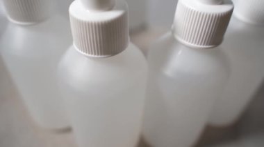 Fabrikada çalışıyor, şişe ilaçlıyor. Dezenfekte edici ile yakın plan bir şişe. Alkol antibakteriyel dezenfektan spreyi fabrikası. Koronavirüs covid-19 'dan antiseptik koruyucu.