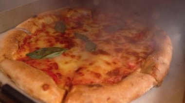 Pizzayla buharlı kutuyu açmak. Taze pizza dumanlı kutuda.