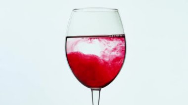 Şarap kadehi dolu ve kırmızı mürekkep yayılıyor. Kırmızı şarap kâseyi doldurur.