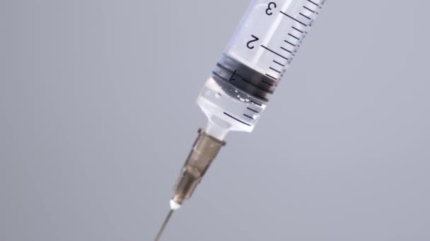 Syringe is filled with liquid on a grey background. Isolate. Close-up of a Syringe with the needle in the laboratory with liquid inside — Stock Video