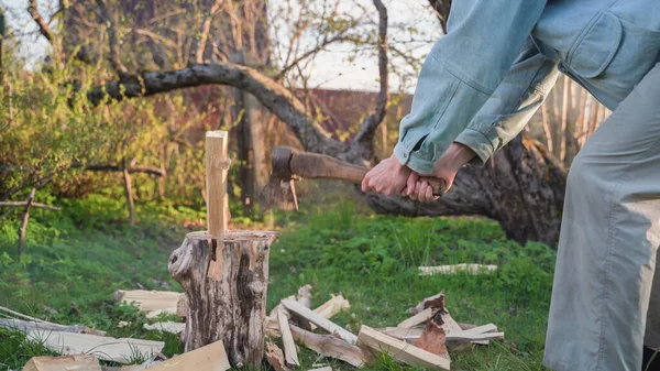 Чоловік подрібнює деревину на дерев'яному майданчику. Журнал різання іржавої сокири — стокове фото