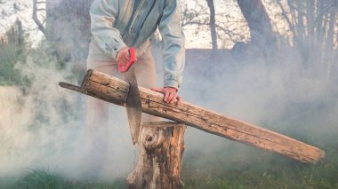 Fırın için el yapımı odun. Adam büyük kütükleri kesiyor.
