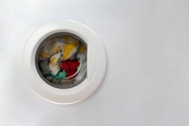 Çamaşır makinesinin ön kapısında çamaşır makinesiyle. Boşluğu ve beyaz arkaplanı kopyala