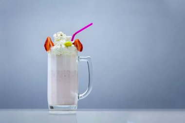 Bardakta milkshake, üstünde de saman ve krema.