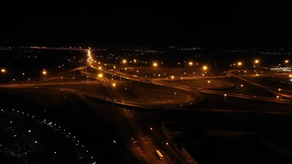 Night Aerial view of highway cloverleaf interchange intersection with ramps, heavy traffic, aerial. Road interchange with busy urban traffic — Stock Photo, Image
