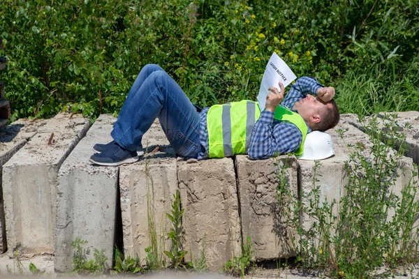 Worker reads the layoff notice outdoor. Unemployment concept. Coronavirus aftermath.