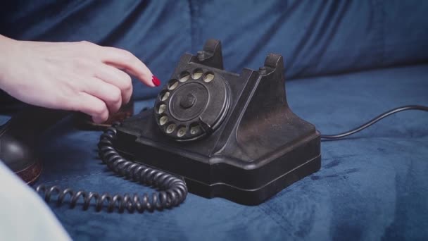 Kvinna på en soffa med en grön retrotelefon. — Stockvideo