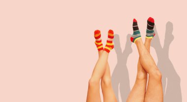 Komik çizgili çoraplar. Evli bir çiftin bacakları. Mercan Pembesi 'nde izole edilmiş.