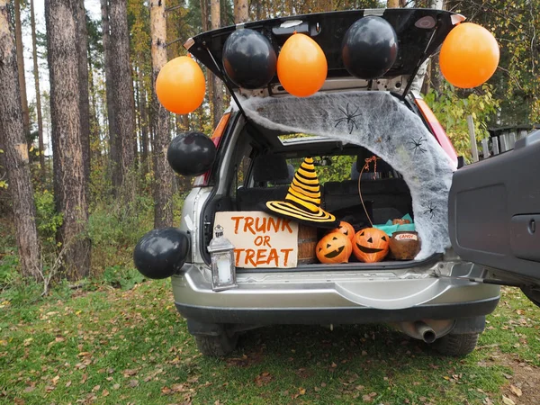 Trick or trunk. Concept celebrating Halloween in trunk of car. New trend celebrating traditional October holiday outdoor. Social distance and safe alternative celebration during coronavirus covid-19