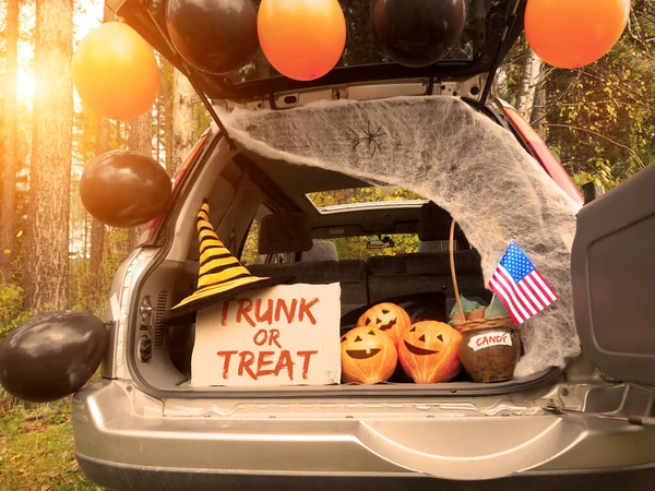 Trick or trunk. Concept celebrating Halloween in trunk of car. New trend celebrating traditional October holiday outdoor. Social distance and safe alternative celebration during coronavirus covid-19