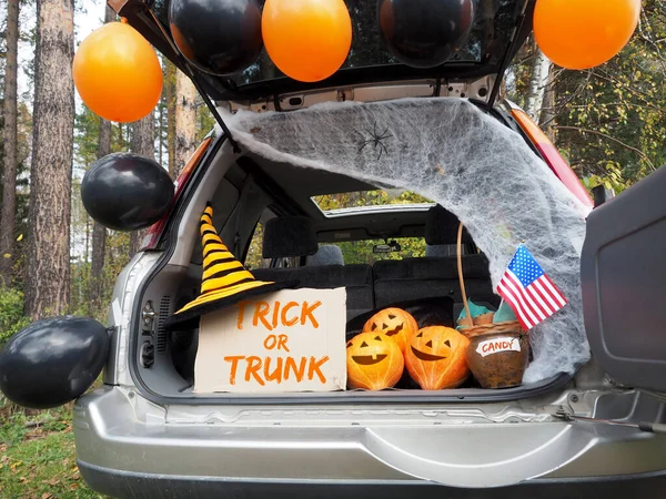 Trick or trunk. Concept celebrating Halloween in trunk of car. New trend celebrating traditional October holiday outdoor. Social distance and safe alternative celebration during coronavirus covid-19