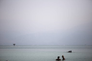 Ölü Deniz'in arka planı gri bir sis mesafe Yahudi yıldaki tuz melodileri ile ıssız sahil.