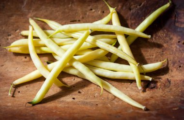 görüntü ham sarı-yeşil çalı fasulyesi bir koyu kahverengi ahşap yüzeyde bir avuç