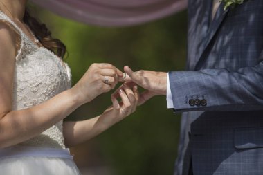 Gelin damat Bahçe bulanık arka planda bir yüzük veriyor