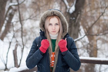 Sıcak bir ceket bir kış parkta uzun sarı saçlı güzel bir anlatım genç kız portresi