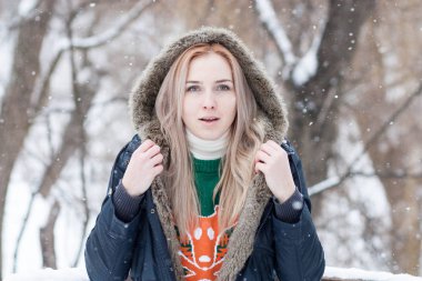 karlı bir kış park bulanık bir arka plan üzerinde uzun sarı saçlı güzel anlamlı genç kız