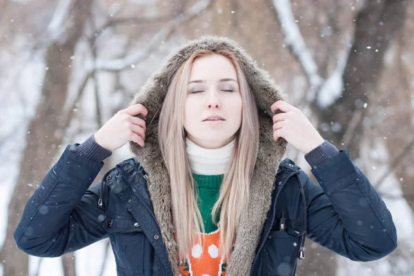 karlı bir kış park bulanık bir arka plan üzerinde uzun sarı saçlı güzel anlamlı genç kız