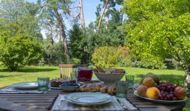 Güneşli bir günde, bulanık arka planda olgun meyveler ve lezzetli aromatik özlerle servis edilen ahşap masa..