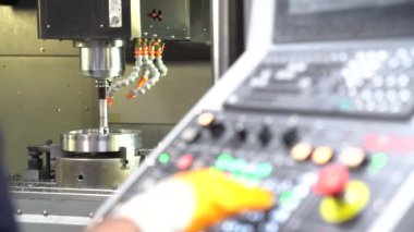 Bir fabrika işçisi cnc makinesini programlıyor veya kontrol ediyor
