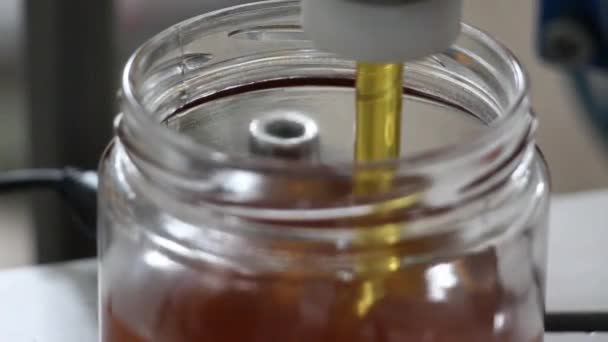 Il processo di produzione del miele. Versando, riempiendo il miele a vaso. sistema immunitario Cibo industriale . — Video Stock