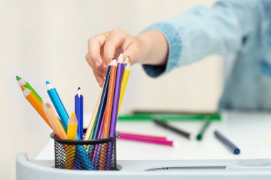 Çocuk çizim için bir kalem alıyor, çocuklar işyerinde.