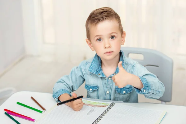 Adorable niño preescolar da pulgares hacia arriba. Retrato interior — Foto de Stock