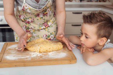 Anne ve oğlu kurabiye hamuru hazırlıyorlar.
