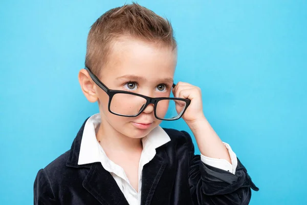 Lindo niño en gafas padres y traje hace una cara sorprendida —  Fotos de Stock