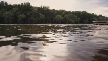 Gün batımı göl ya da nehir suyundan yansıyor. Su yüzeyinden ateş ediliyor