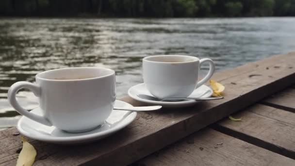 Großaufnahme der weiblichen Hand nimmt eine weiße Tasse Kaffee. Kaffee am Morgen. — Stockvideo