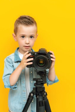 Dijital kamerayla poz veren küçük çocuk.