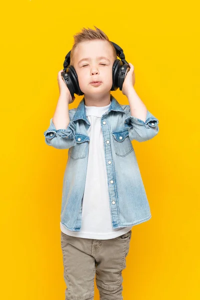 Schöner stylischer Junge hört Musik über Kopfhörer und genießt — Stockfoto