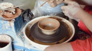 Çanak çömlek atölyesinde el yapımı çömlek boyayan bir zanaatkar.