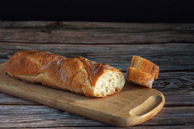 Kesme tahtasındaki dilimlenmiş baget ekmeği.