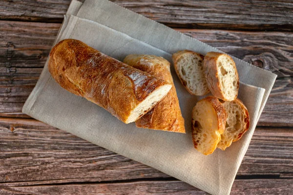 Baguete francesa fatiada na tábua de corte — Fotografia de Stock