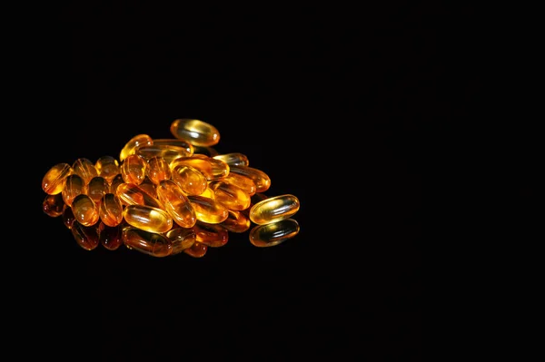 Orange medicine capsules on a black background