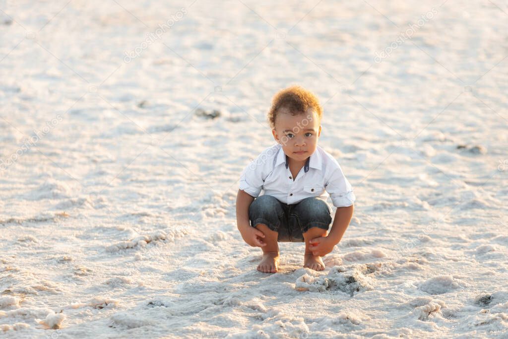 Cute happy mixed race baby boy portrait. Cute mixed race little boy playing on the beach of the estuary