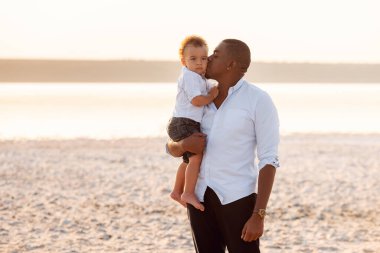 Genç Baba, küçük oğluna sarılıp öpüyor.