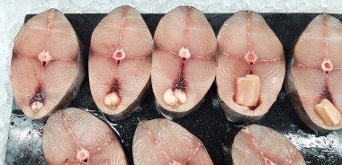 Hint-Pasifik kral uskumrularından, benekli uskumrulardan ya da Scomberomorus 'tan bir sürü taze dilimlenmiş balık pazarındaki müşteriler için buz tepsisi.