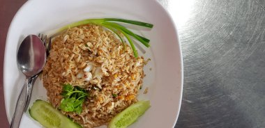 Üst ya da düz yengeç eti dilimlenmiş pilav, salatalık, kişniş, taze soğan ya da soğan ve çatalla kaplanmış kaşık, paslanmaz çelik masa ya da arka planda soldaki fotokopi alanı
