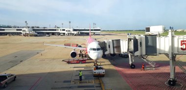 Songkhla, Tayland - 18 Temmuz 2019: Park etmiş ve yolcu bekleyen uçak mavi gökyüzü ve Hat Yai havaalanındaki terminal binası arka planı ile içeri girin - ulaşım ve araç