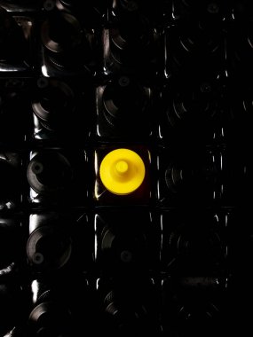 Kırtasiyede satılık bir sürü plastik mürekkep şişesi. Birinde sarı kapak var. Farklı konsept.