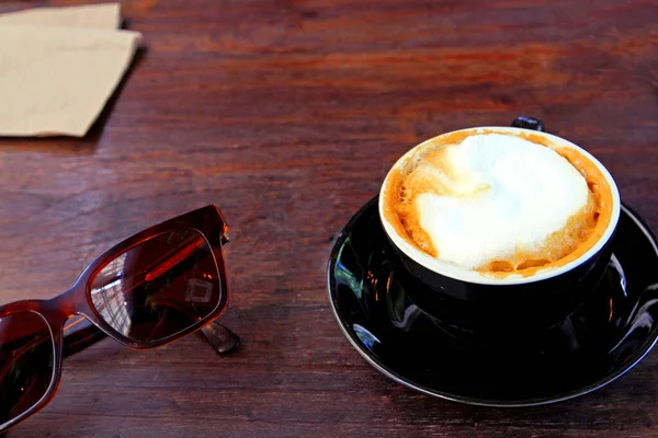 Zwart Kopje Warme Cappuccino Met Bruine Zonnebril Papieren Handdoek Donkerbruine — Stockfoto