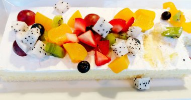 Taze ejderha meyvesi, çilek, kivi, ahududu, üzüm ve şeftalili lezzetli beyaz pasta.