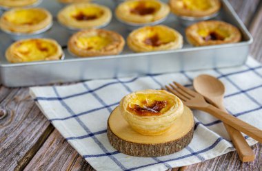 Tatlı yumurtalı tart veya Portekiz yumurtalı tart Tahta tahtada krema ve ahşap kaşık