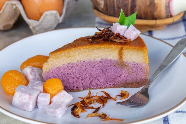 close-up of taro chiffon cake topped with Thai taro custard and fried onion on white plate, Concept of dessert and Thai dessert.