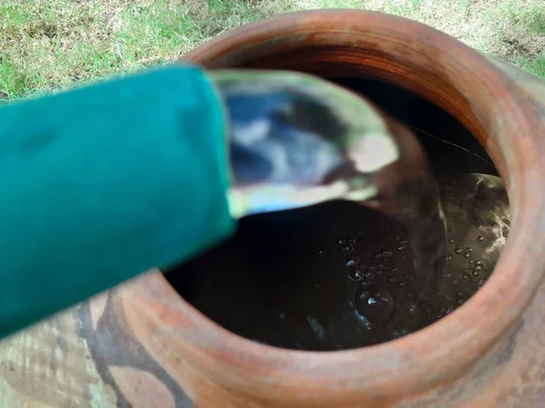 Filling water in a clay pot in summer during lack of water in rural areas.