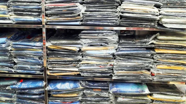 Kumaş galerisindeki raflarda sıralanmış çeşitli kumaşlar.